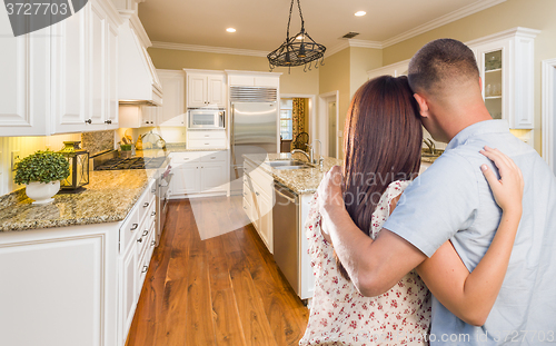 Image of Young Hopeful Military Couple Looking At Custom Kitchen