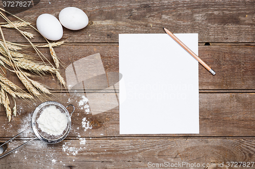 Image of The flour  and eggs on an wooden background