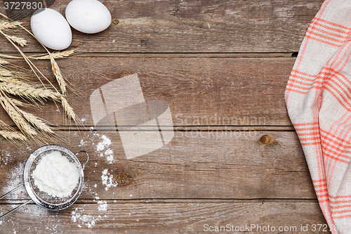 Image of The flour  and eggs on an wooden background