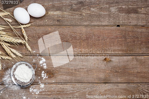 Image of The flour  and eggs on an wooden background