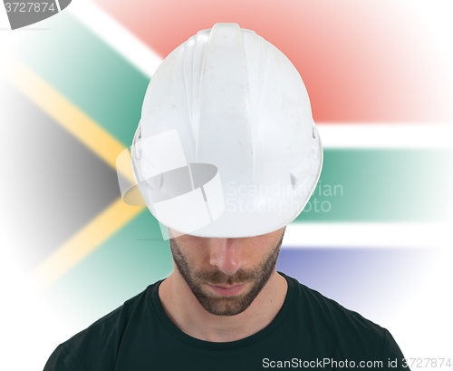 Image of Engineer with flag on background - South Africa