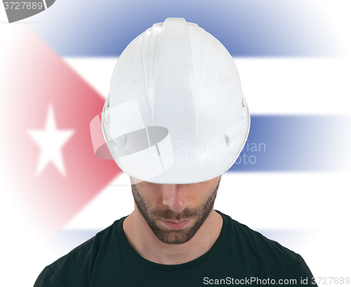 Image of Engineer with flag on background - Cuba