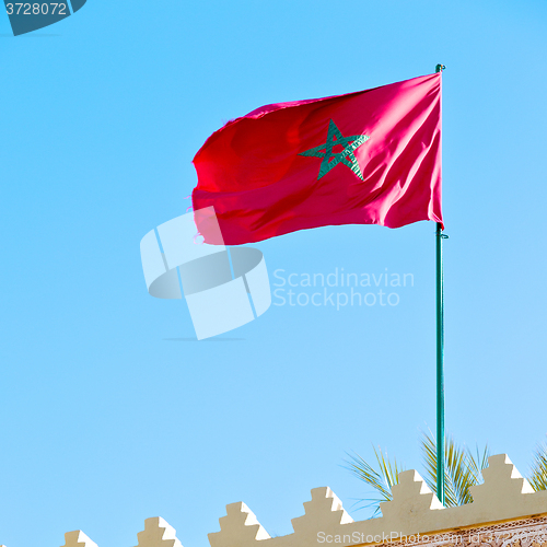 Image of tunisia  waving flag in the blue sky  colour and battlements  wa