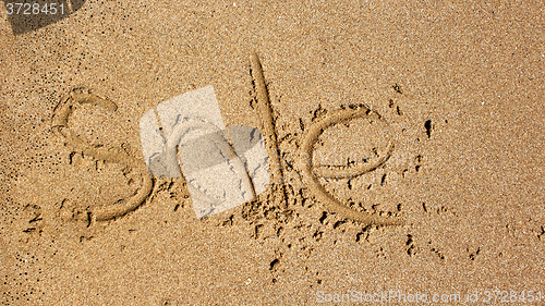 Image of Word sale handwritten in sand