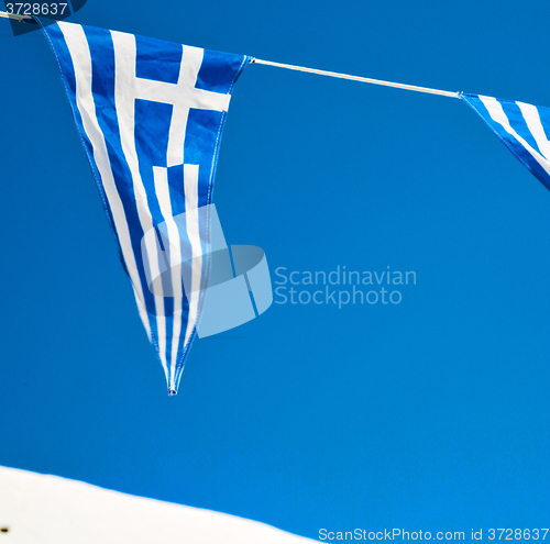 Image of waving greece flag in the blue sky and flagpole