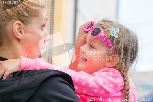 Image of Young mother amuses his three-year daughter