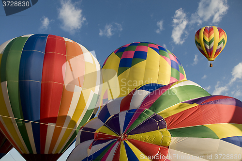 Image of Hot-air balloons inflating with another balloon already aloft