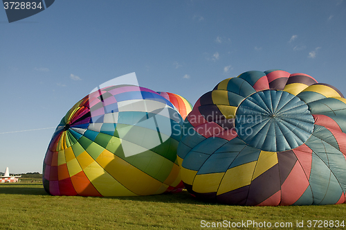 Image of Two hot-air balloons inflating on the ground