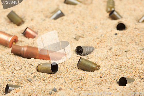 Image of cartridge cases on the sand.