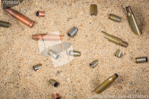 Image of cartridge cases on the sand.