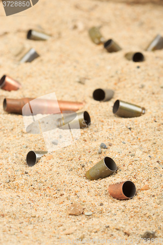 Image of cartridge cases on the sand.