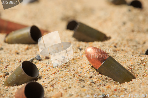 Image of cartridge cases on the sand.