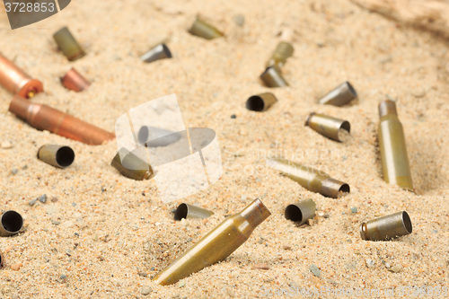 Image of cartridge cases on the sand.