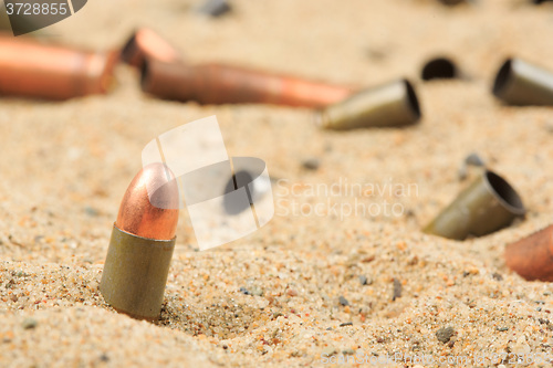 Image of cartridge cases on the sand.