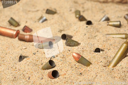 Image of cartridge cases on the sand.