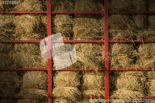 Image of Hay bales piled within a cart lit diagonally