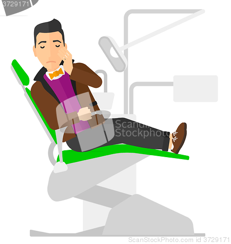 Image of Man suffering in dental chair.