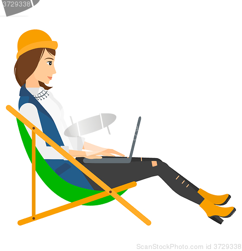 Image of Business woman sitting in chaise lounge with laptop.