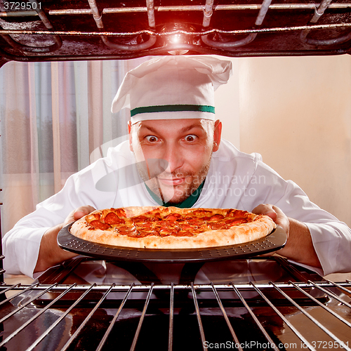 Image of Chef cooking pizza in the oven.