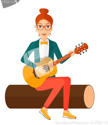 Image of Woman playing guitar.