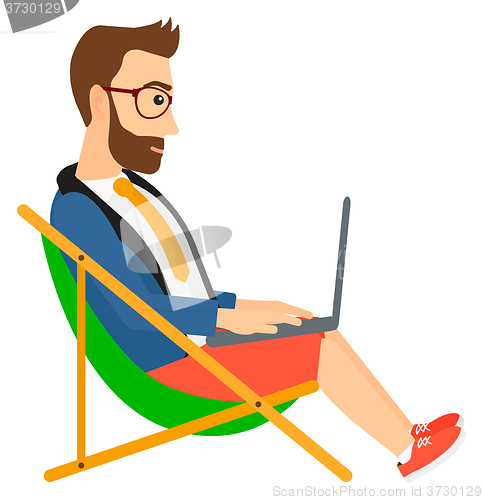 Image of Businessman sitting in chaise lounge with laptop.