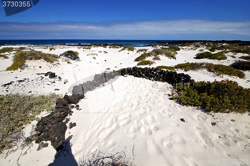 Image of spain white  beach  spiral of black rocks