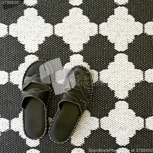 Image of Leather sandals on black and white rug