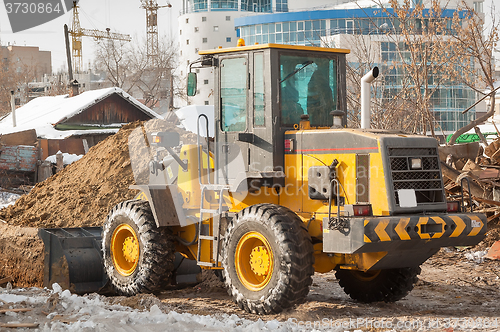 Image of Tractor removes debris from building demolition