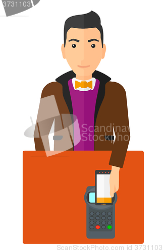 Image of Man paying using smartphone.