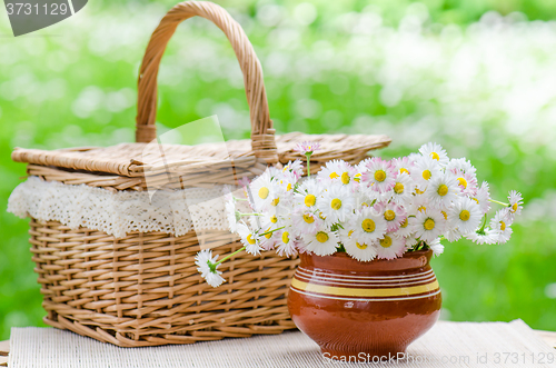 Image of A bouquet of daisies in a pot on the table for a picnic