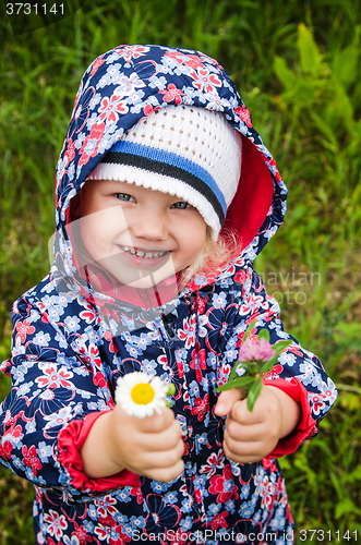 Image of Portrait of a little girl with wild flowers in the hands