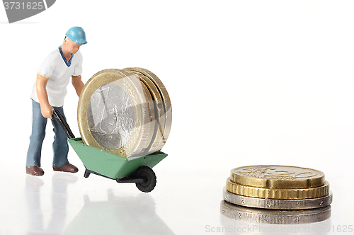 Image of Miniature worker drives euro coins