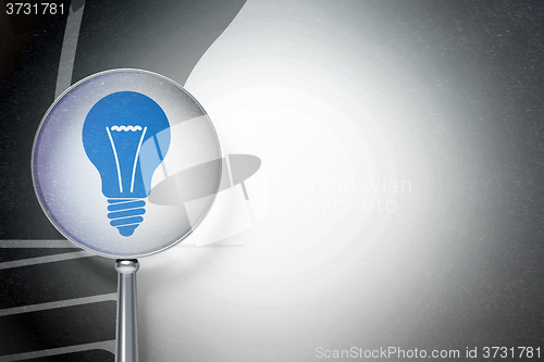 Image of Finance concept:  Light Bulb with optical glass on digital background
