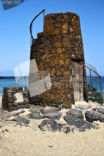 Image of tower spain  hill yellow  beach    black rocks   lanzarote 