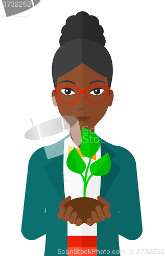 Image of Woman holding plant.