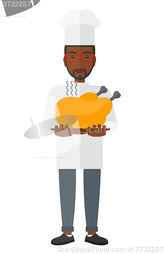 Image of Man holding roasted chicken.
