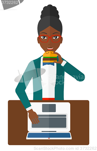 Image of Woman eating hamburger. 