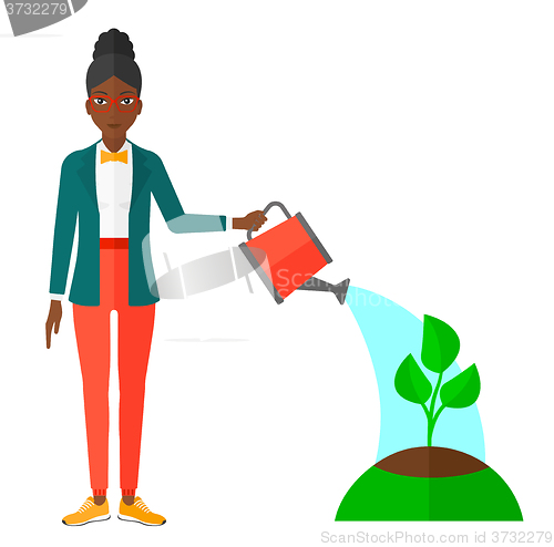 Image of Woman watering tree.