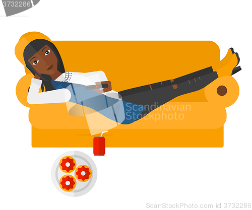 Image of Woman lying on sofa with junk food.