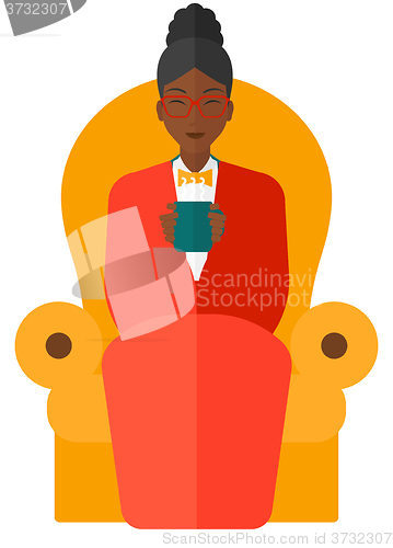 Image of Woman sitting in chair with cup of tea.