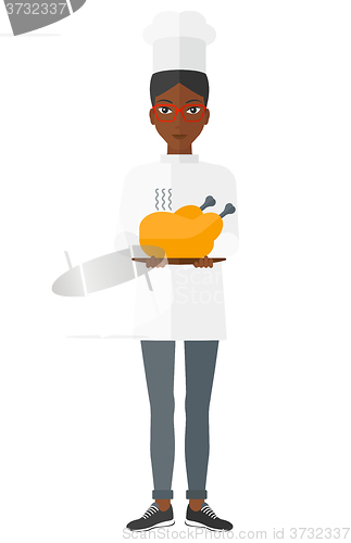 Image of Woman holding roasted chicken.