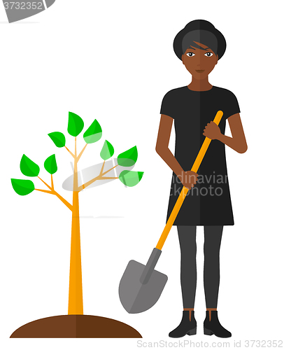 Image of Woman plants tree.