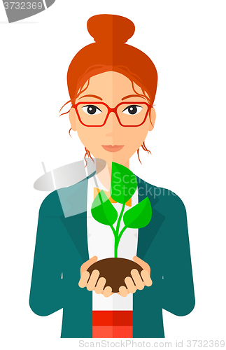 Image of Woman holding plant.