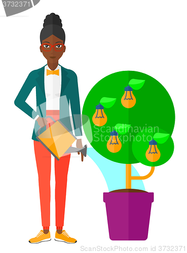 Image of Woman watering tree with light bulbs.