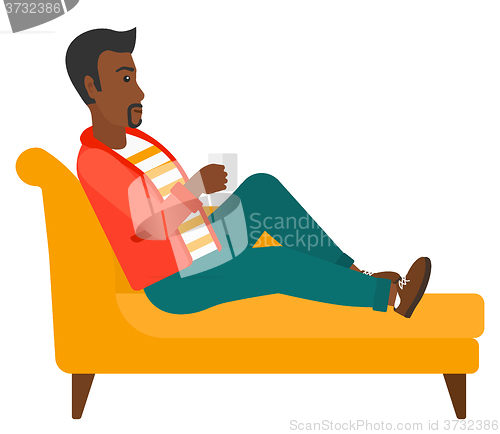 Image of Man lying with cup of tea.