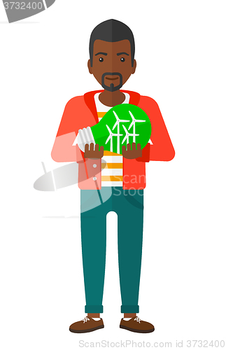 Image of Man holding windmill inside the lightbulb.