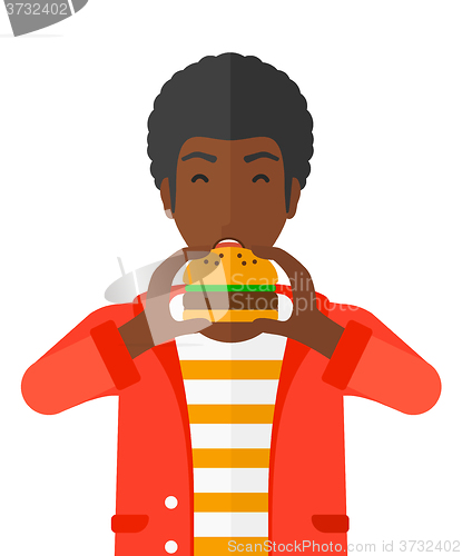 Image of Man eating hamburger. 