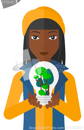 Image of Woman with lightbulb and trees inside.