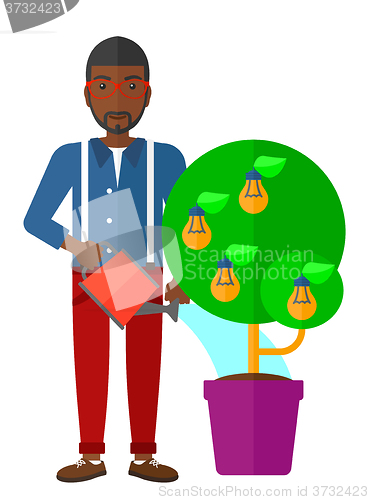 Image of Man watering tree with light bulbs.