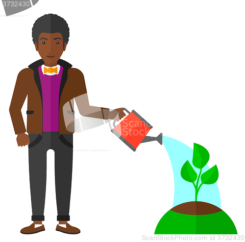 Image of Man watering tree.